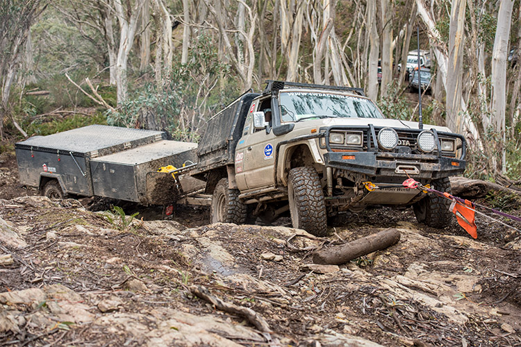 4WD towing a camper trailer through a muddy road